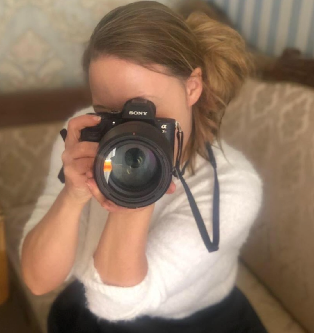 Feminin person sidder med stort professionelt kamera oppe og er kalr til at skyde billeder af dig.